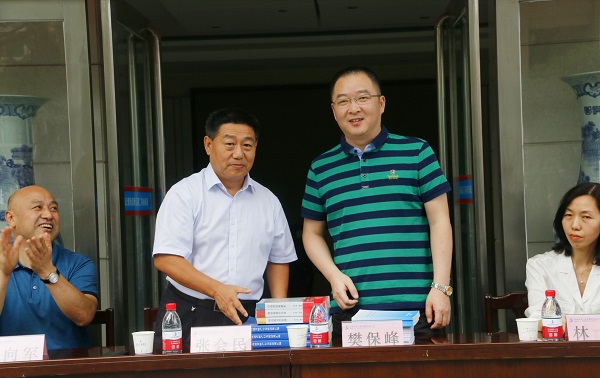 新乡市牧野区税务局党委书记、局长樊保峰向2UP.IO（中国）党委书记张会民赠送税法知识书籍.jpg
